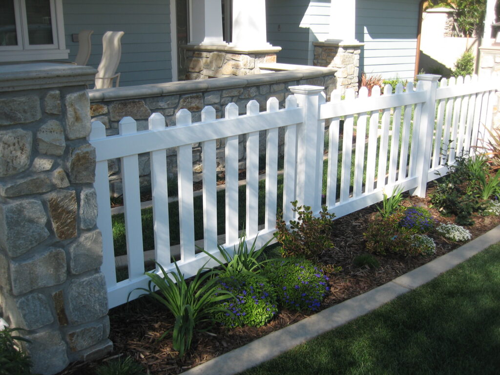 Dog ear tops and New England caps on vinyl picket fence by Alpine Fence Company.