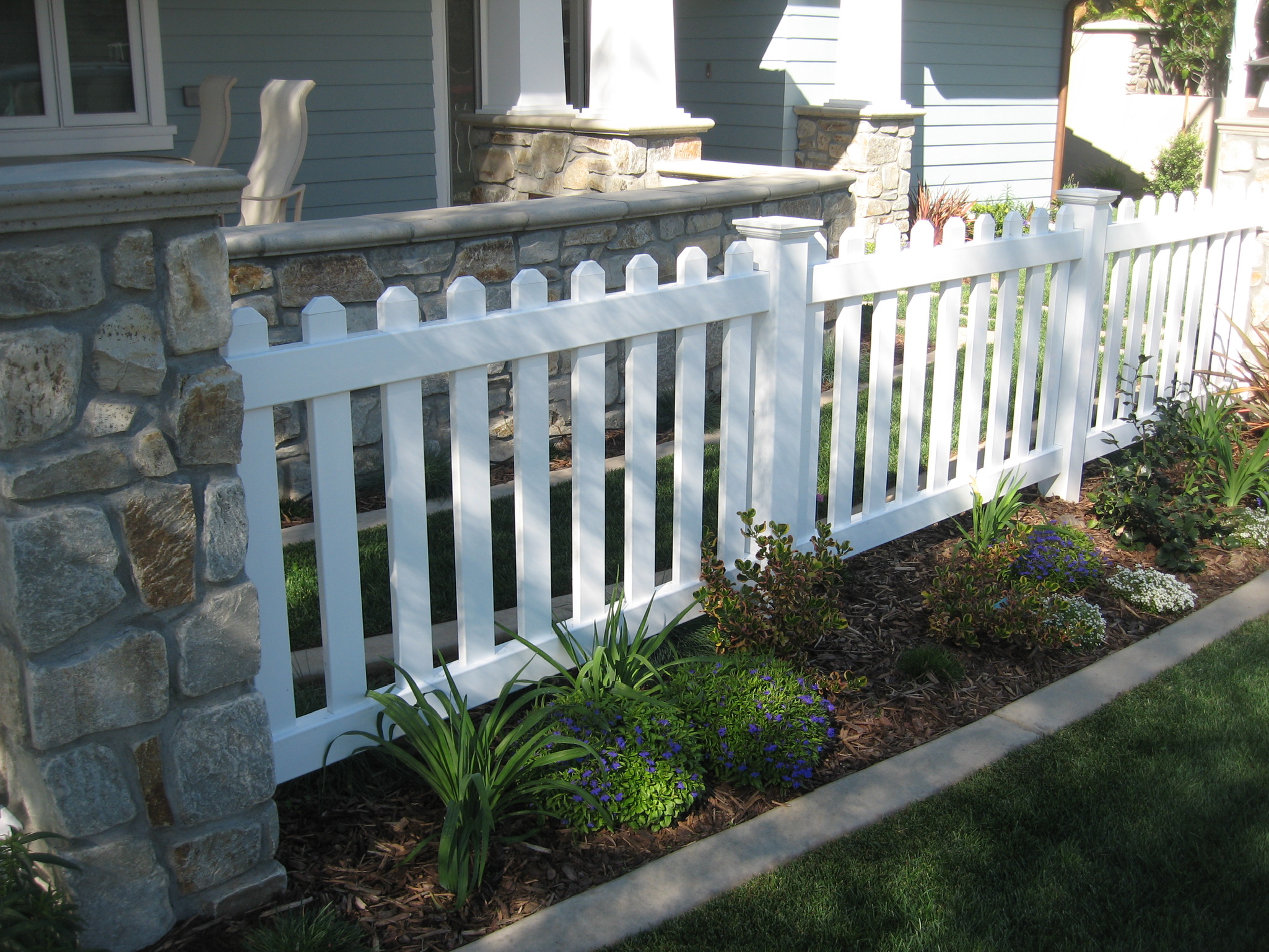 Dog ear tops and New England caps on vinyl picket fence by Alpine Fence Company.