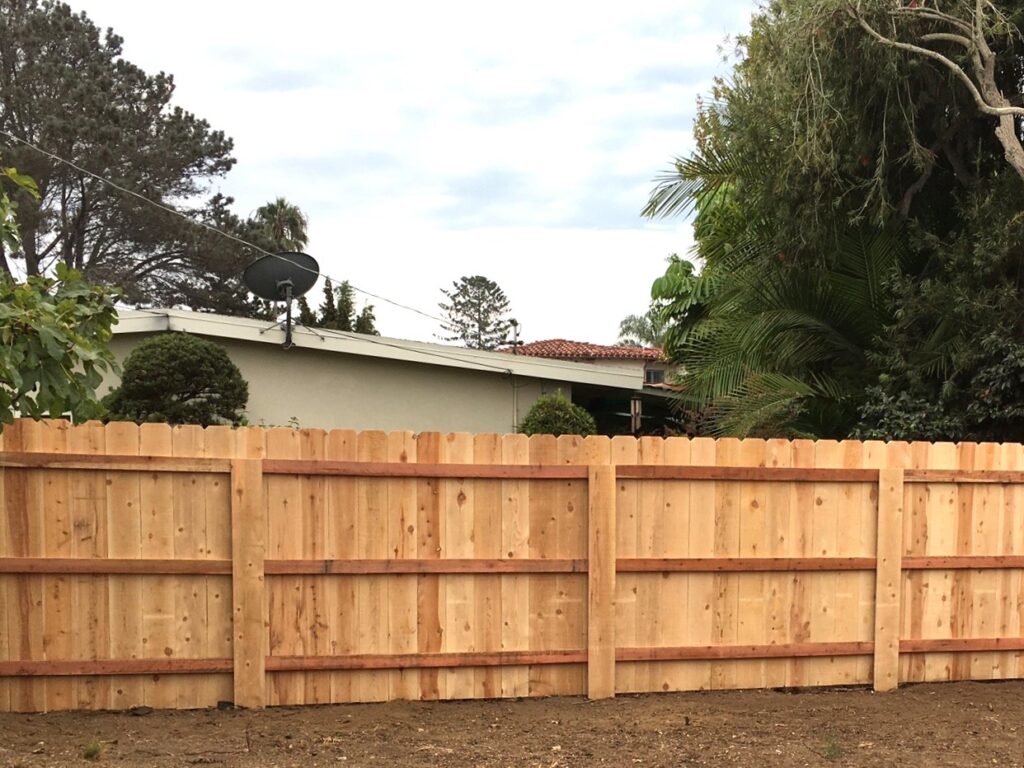 Dog-eared cedar fence with covered steel post by Alpine Fence Company.