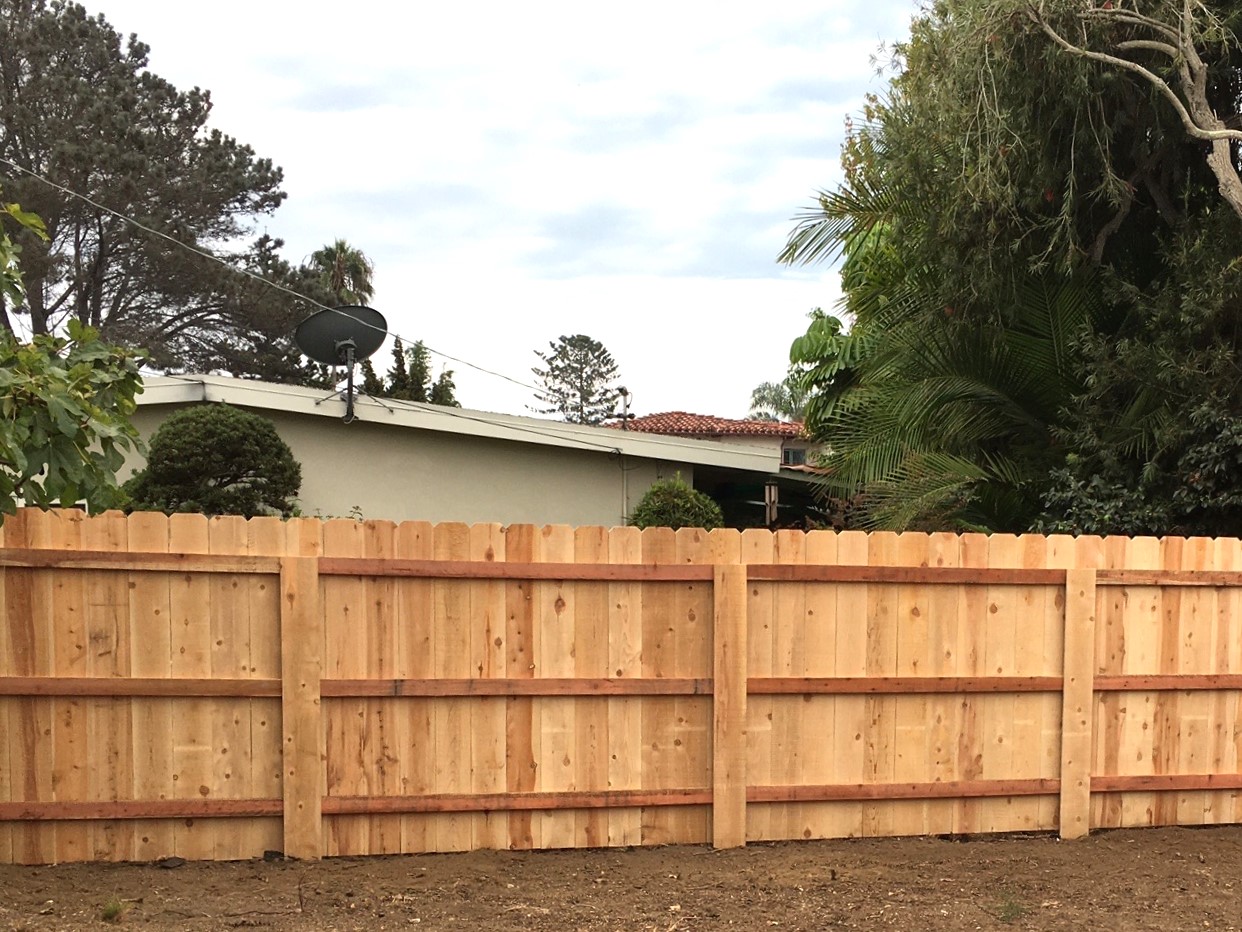 Dog-eared cedar fence with covered steel post by Alpine Fence Company.