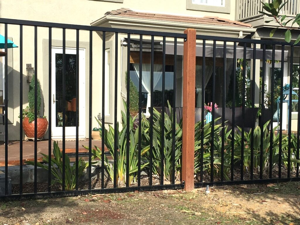 Ornamental iron on wood posts by Alpine Fence Company.