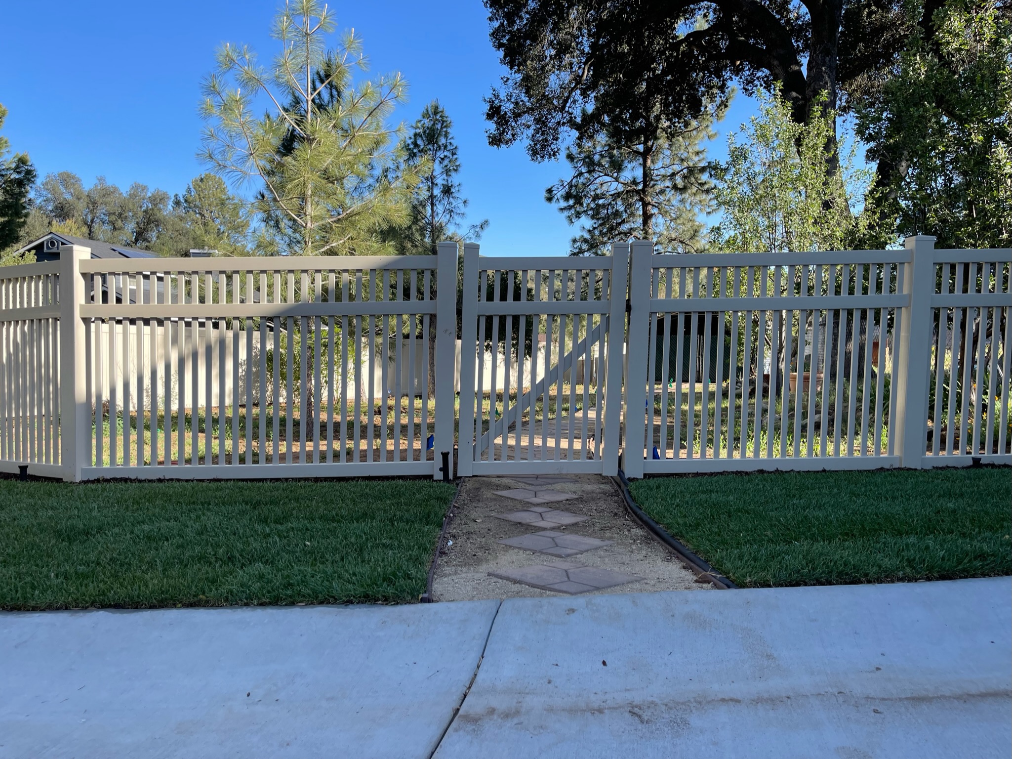 Universal vinyl fence with 2-inch space by Alpine Fence Company.