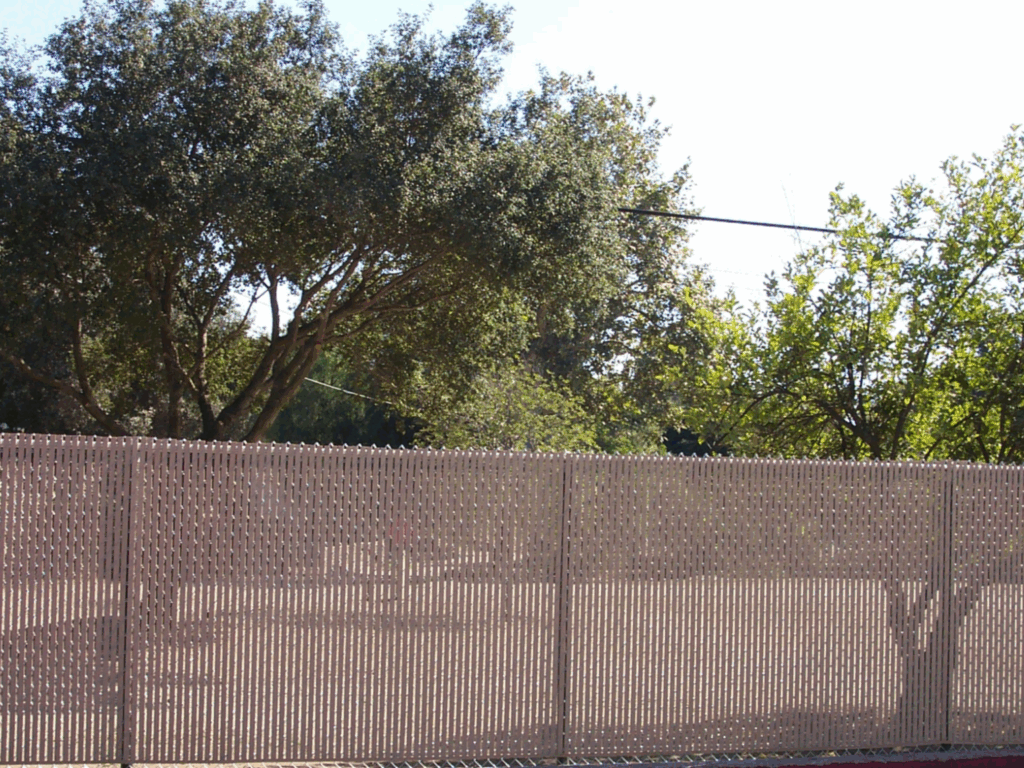 75% tan vinyl privacy slat over a chain-link fence by Alpine Fence Company.