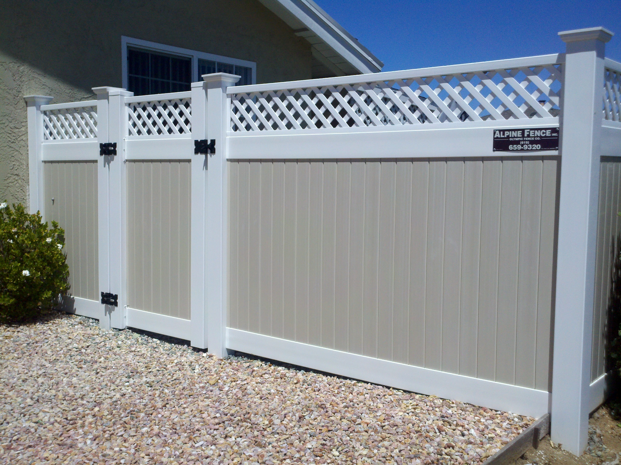 Two-tone lattice top vinyl fence by Alpine Fence Company.