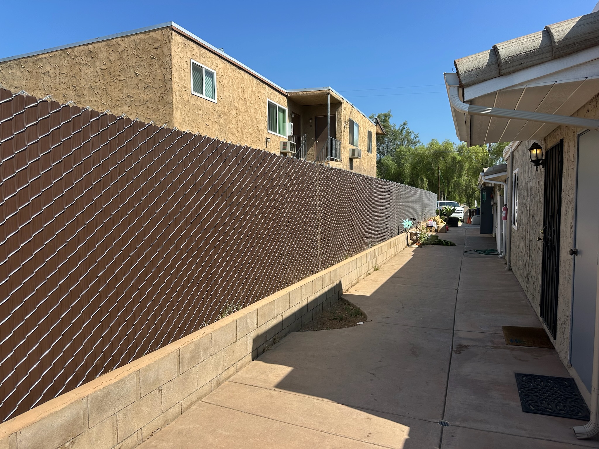 95% brown vinyl slats over a chain-link fence by Alpine Fence Company.