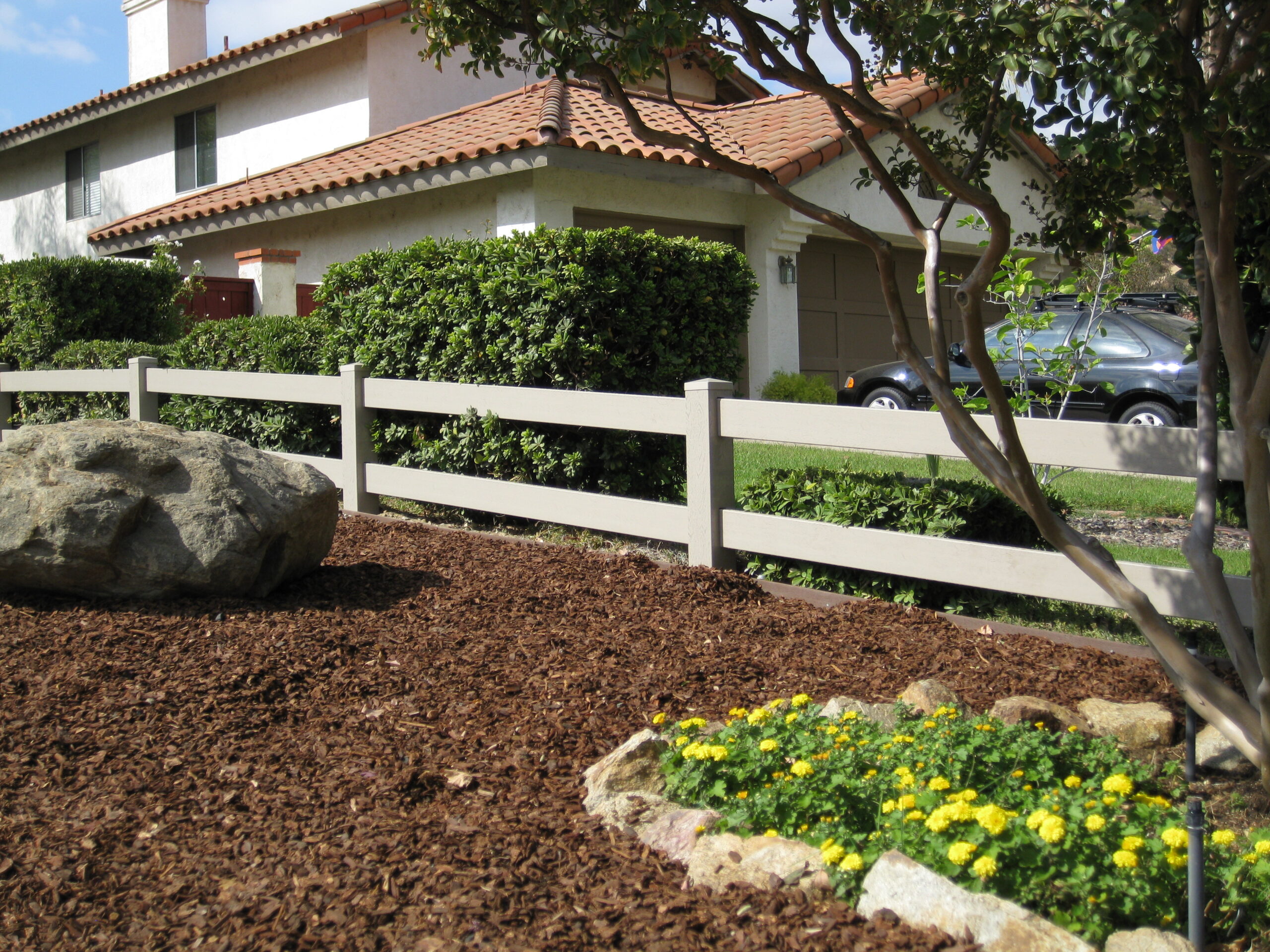 Clay vinyl ranch rail fence by Alpine Fence Company.