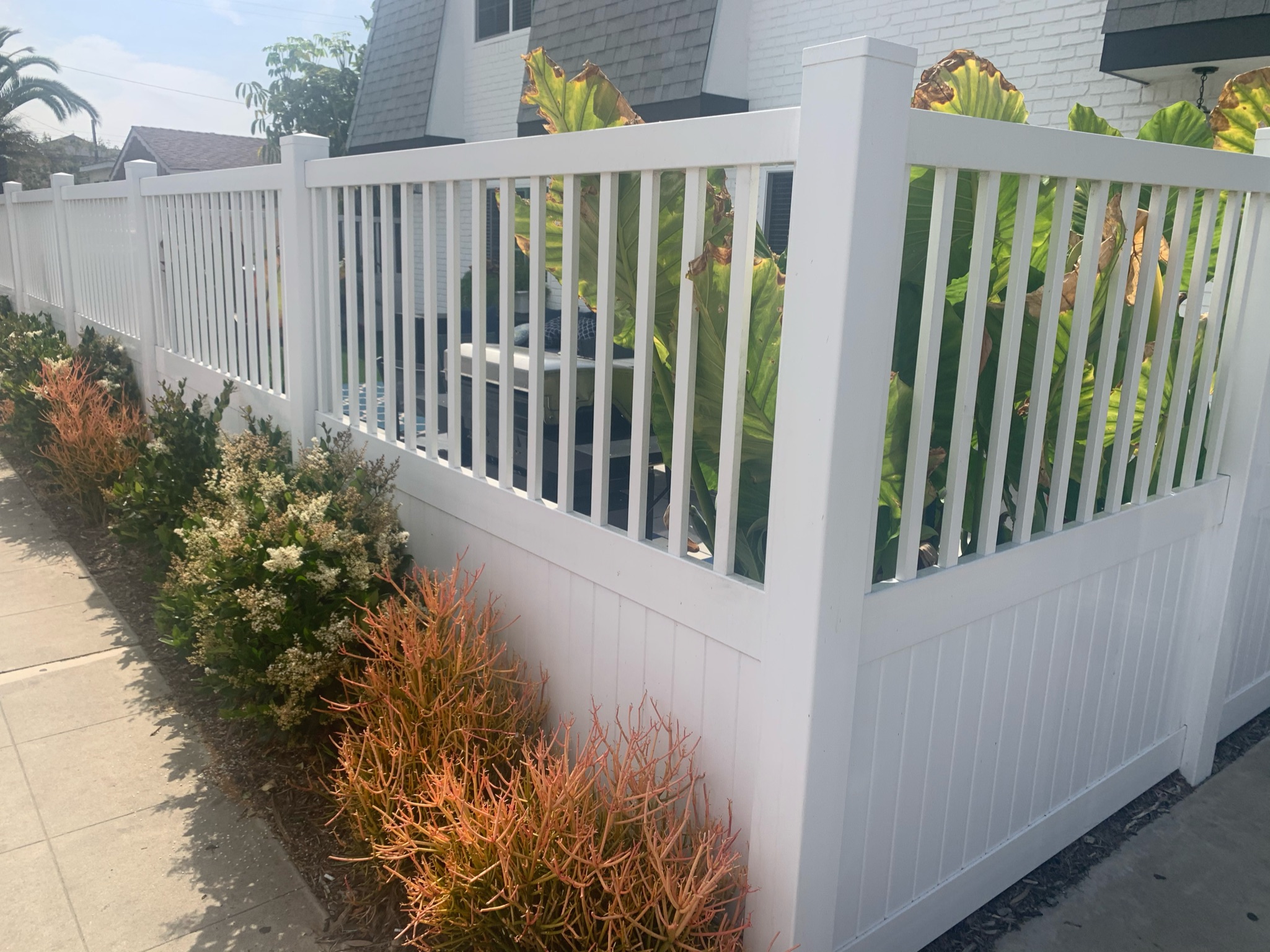 Privacy vinyl fence with universal top by Alpine Fence Company.