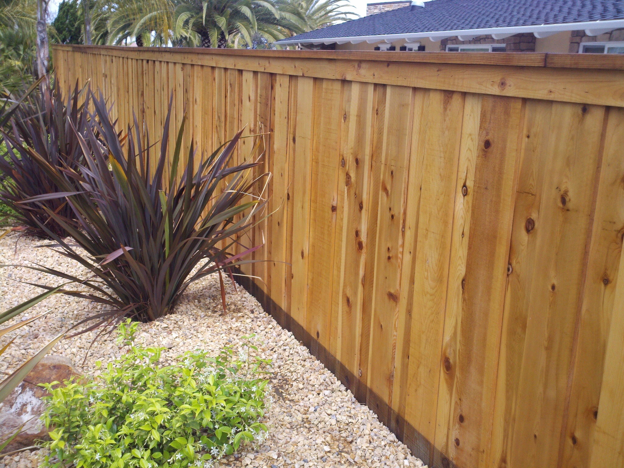 Board-on-board wood fence with cap and trim and steel posts by Alpine Fence Company.