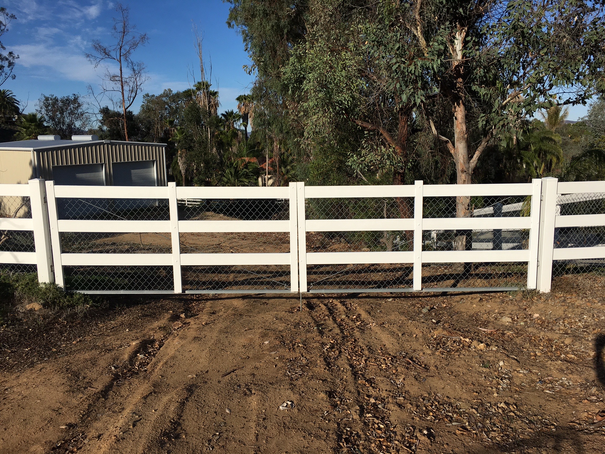 Steel-framed double vinyl gate by Alpine Fence Company.