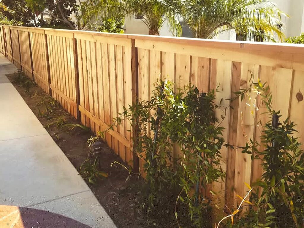Board-on-board fence with cap and trim by Alpine Fence Company.