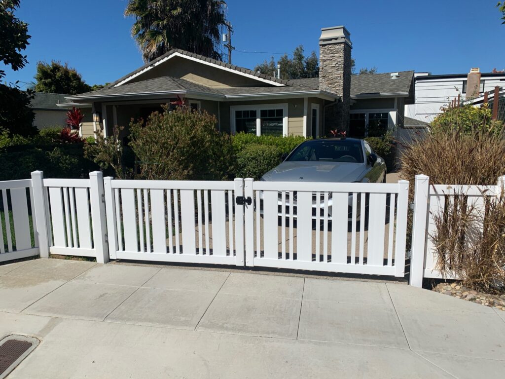 Decorative vinyl fence with large drive gate by Alpine Fence Company.