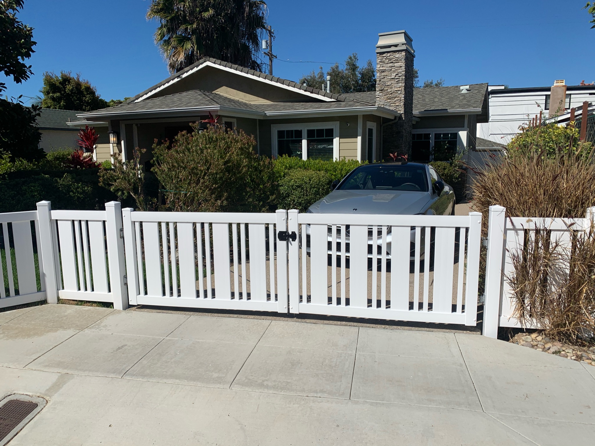 Decorative vinyl fence with large drive gate by Alpine Fence Company.