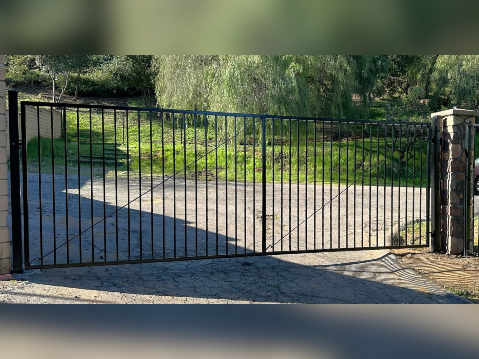 Ornamental iron standard driveway gate by Alpine Fence Company.