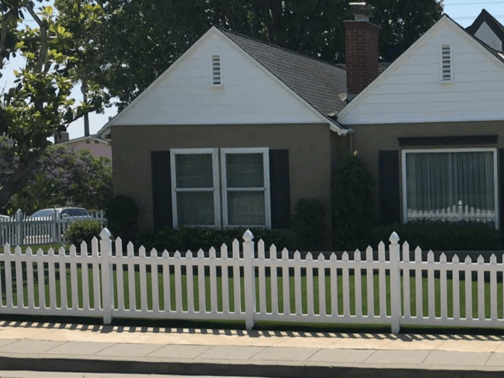 Scalloped vinyl picket fence with gothic caps by Alpine Fence Company.