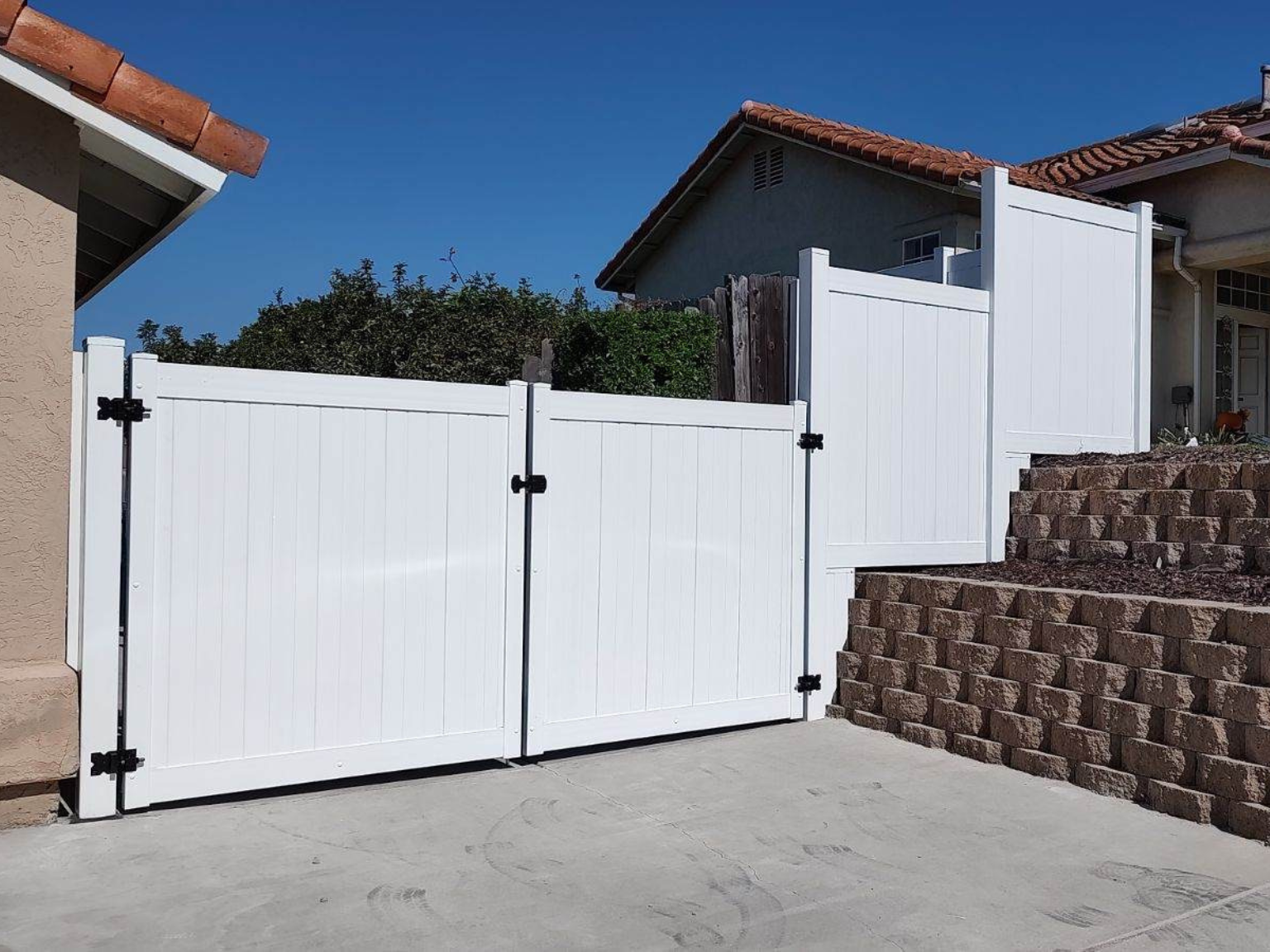 Large driveway vinyl privacy gates by Alpine Fence Company.
