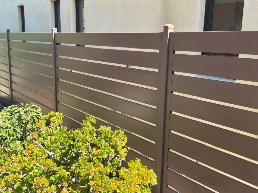 11. Semi-privacy metal fence with horizontal brown slats.