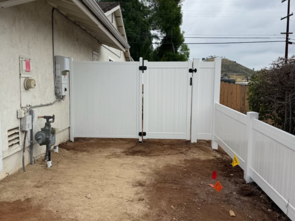 6. White metal privacy fence connected to a vinyl privacy gate.