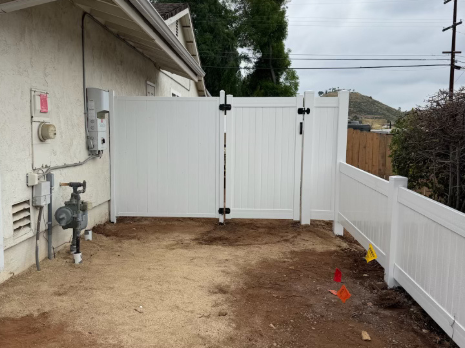 6. White metal privacy fence connected to a vinyl privacy gate.