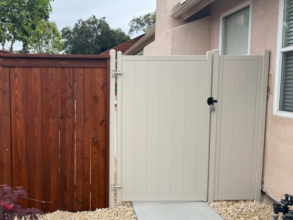 3. Vertical metal privacy fencing attached to a wood fence on the side of a home.