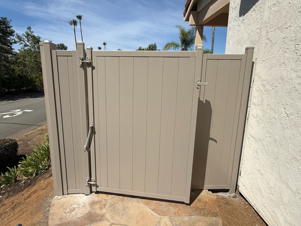 2. Khaki vertical metal privacy fencing with gate.